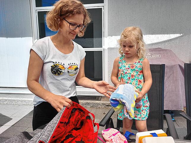 Ramona Kaiser packt mit Tochter Merle die Badetasche. Badeanzug und Handtuch sind ein Muss, aber auf die Schwimmhilfen will Merle bald ...