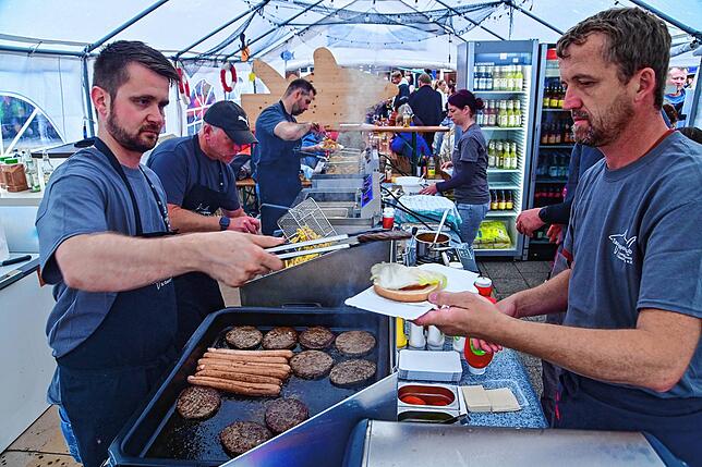 Teamarbeit am Stand vom Tauchsportclub Longimanus. Markus Graf (links) und Christian Brink kreieren einen Burger mit saftigem Fleisch ...