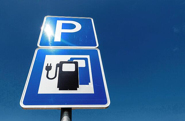 Ein Hinweisschild für Parkplätze mit Ladestationen für Elektroautos am Schnellladepark einer Autobahn-Raststätte.