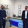 Daniel Benner (links), Teamleiter Forschung und Technologie bei STS, zeigt einen Hochspannungsübertrager (10.000 Volt) für ...