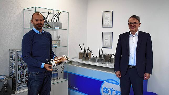 Daniel Benner (links), Teamleiter Forschung und Technologie bei STS, zeigt einen Hochspannungsübertrager (10.000 Volt) für ...
