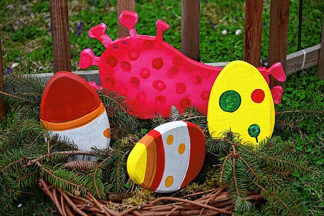 Auch dieses Jahr ist Ostern von Corona geprägt. Das Virus versteckt sich zwischen den Ostereiern.