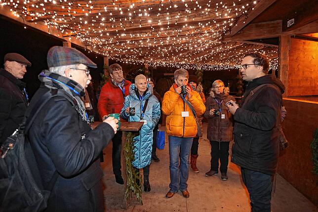 Veranstalter Levin Stracke (rechts im Bild) erklärt, dass es sich bei der Christbaumschänke um einen besonderen Stand handelt, denn er ...