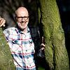 Peter Wohlleben lehnt dort, wo er sich am wohlsten fühlt: An einem Baum. Bild: dpa