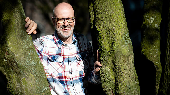 Peter Wohlleben lehnt dort, wo er sich am wohlsten fühlt: An einem Baum. Bild: dpa
