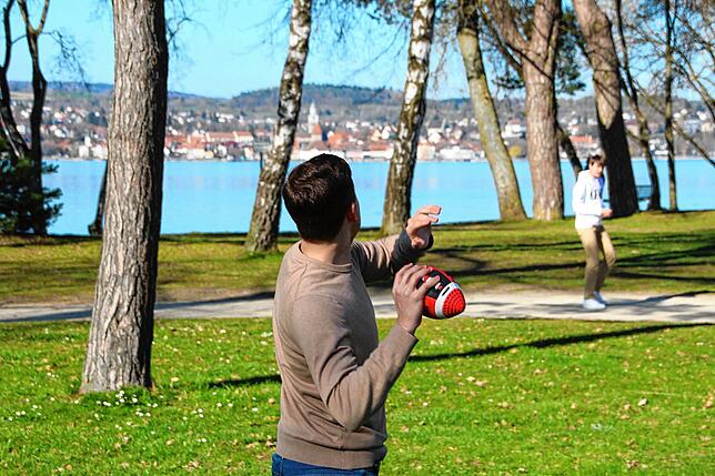 Noah und Julian warfen sich am Ostersonntag im Strandbad Dingelsdorf einen American Football zu.