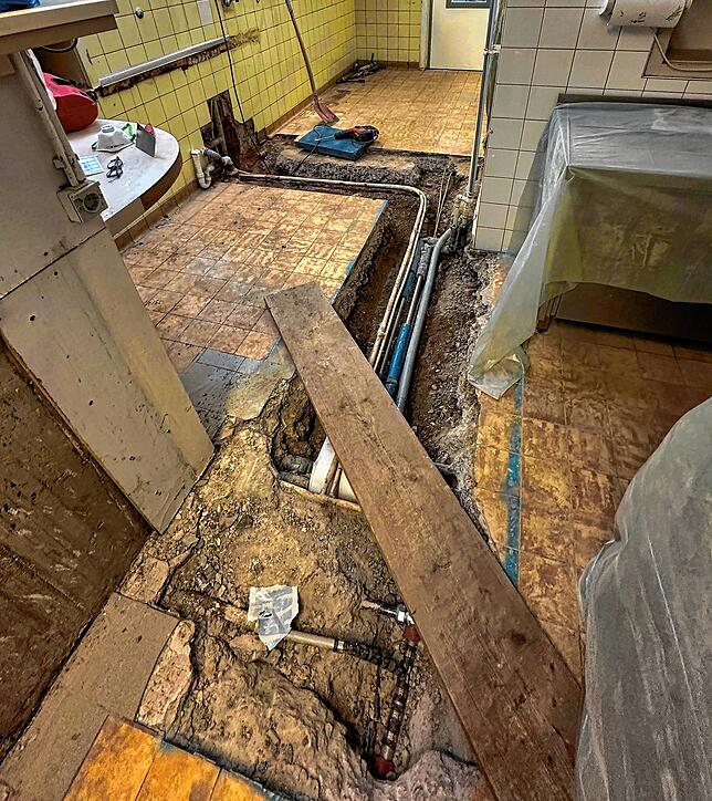 In mühseliger Kleinarbeit werden die im Estrich liegenden Wasserleitungen freigelegt, um den Grund für den Wasserrohrbruch beseitigen zu ...
