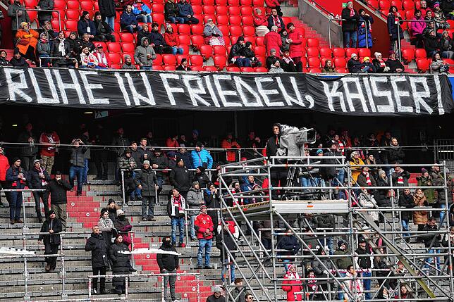 Besucher stehen auf einer Tribüne in der Münchner Arena.