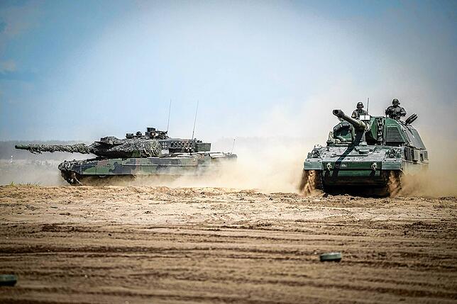 Ein Leopard-2-Kampfpanzer und eine Panzerhaubitze 2000 bei der Nato-Übung „Griffin Storm“ in Litauen – das Bild ...