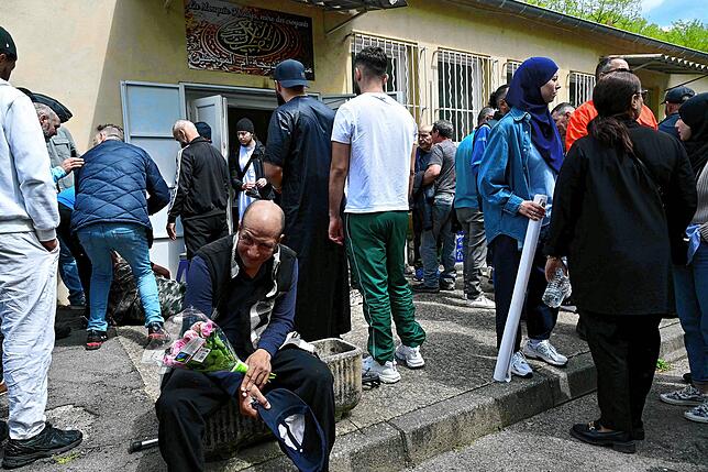 Ein Mann hält Blumen vor der Khadija-Moschee in La Grand-Combe, Südfrankreich, am 27. April 2025 vor einem Gedenkmarsch für Aboubakar, ...