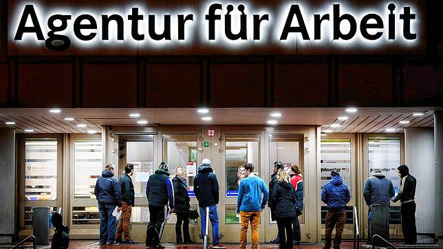 Arbeitssuchende stehen vor einer Bundesagentur für Arbeit.