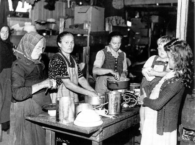 Ihr neues Leben begann im Lager: Heimatvertriebene Frauen bereiten 1948 an einem Tisch im Flüchtlingslager Allach bei München Mahlzeiten zu.