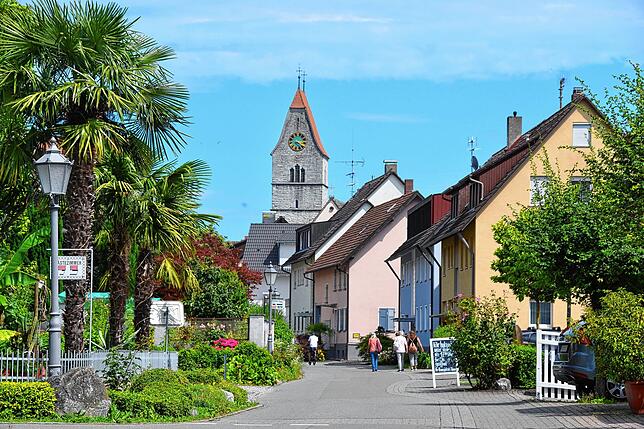 Den Ortskern von Hagnau markiert die Katholische Kirche St. Johann Baptist, im Vordergrund die Hansjakobstraße.