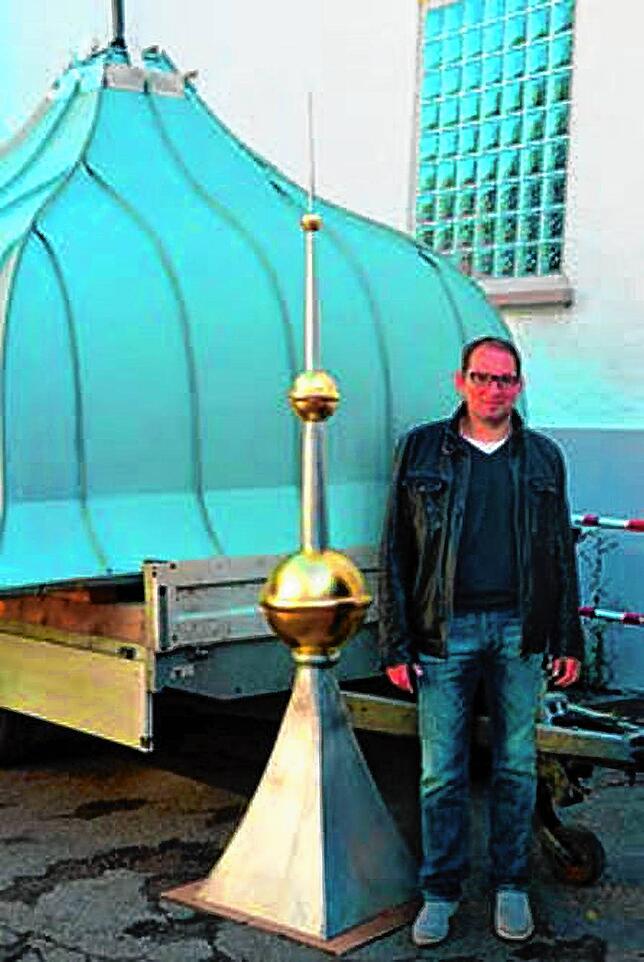 Architekt Andreas Flöß neben der 2,80 Meter hohen Turmspitze. Die größte der drei vergoldeten Kugeln hat einen Durchmesser von 35 ...