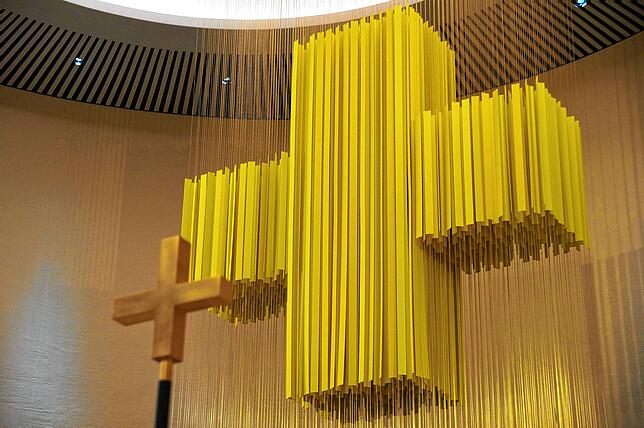 Das Lichtkreuz aus vielen einzelnen Lamellen dominiert jetzt den Chorraum. Im Vordergrund ist das passend gestaltete Vortragekreuz zu ...
