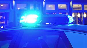 Ein Streifenwagen der Polizei steht mit eingeschaltetem Blaulicht an einem Einsatzort. (Symbolbild)
