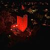Der rot angestrahlte Bergfried der Schlossruine im Schweizer Laufenburg.