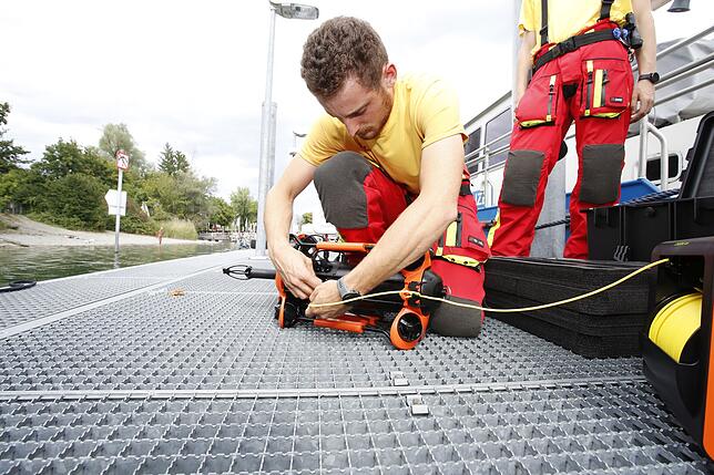 (Archivbild von August 2023) Christoph Schumann befestigt in Konstanz die Leine an dem kleinen Tauchroboter. Auch mit dieser Technik ...