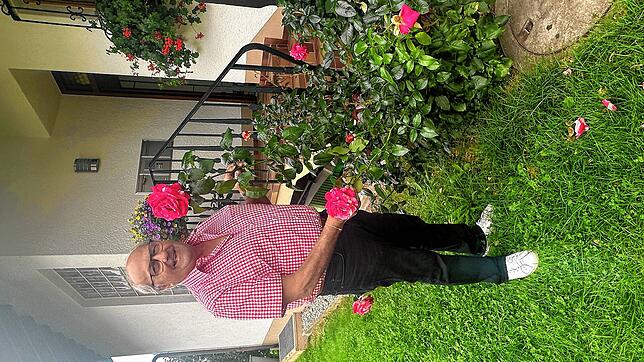 Erich Boll in seinem Garten. „Wenn die Rosen rechtzeitig geschnitten werden, hat man eine tolle zweite Blüte“, sagt er. Bild: Bettina Ebi