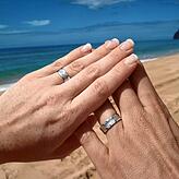 Frischvermählt gehen die Grolls 2009 auf Hochzeitsreise nach Hawaii und fotografieren am Strand ihre Hände mit den Eheringen.