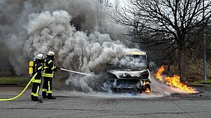 Einsatzkräfte der Feuerwehr Moos löschen das brennende Auto.