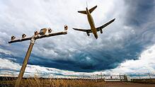 Dunkle Wolken ziehen über einen Airbus A320 hinweg, der am Stuttgarter Flughafen landet.