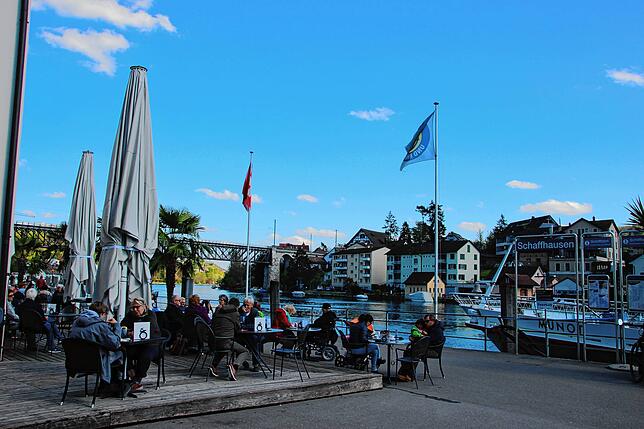 Auch an der Schaffhauser Schifflände am Rhein genießen viele Besucher dieser Restaurant-Terrasse das schöne Wetter und die ...