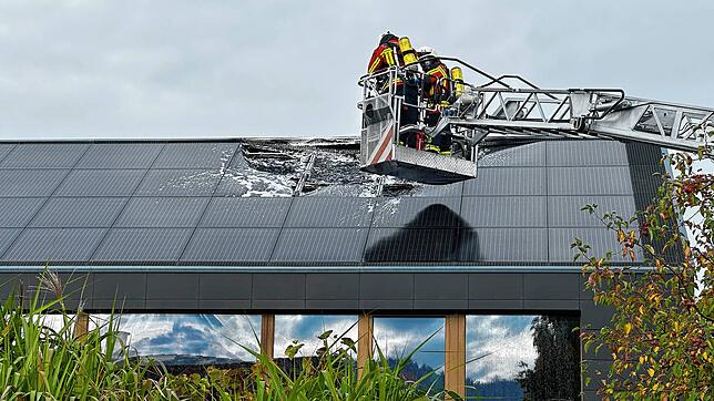 Zwei Feuerwehrleute im Korb der Drehleiter bei den Löscharbeiten an einer defekten In-Dach-Photovoltaik-Anlage in Wahlwies. Das Bild ...