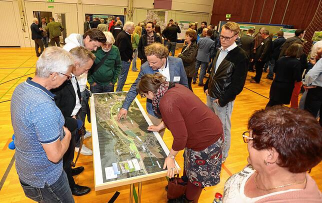 Projektleiter Valentin Wind erläutert an einem Plan, wie es mit und auf der Baustelle weitergehen soll.