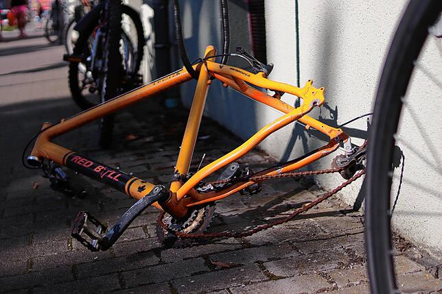 Ein ganz besonders ausgeschlachtetes Exemplar von Fahrradleiche: kein Sattel, keine Räder und ein abgebrochener Lenker. Abgeschlossen ...
