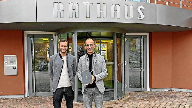 Bürgermeister Jörg Frey (rechts) mit Andreas Kreyer bei der Übergabe der Jubiläums-Kuckucksuhr. Foto: Gemeinde