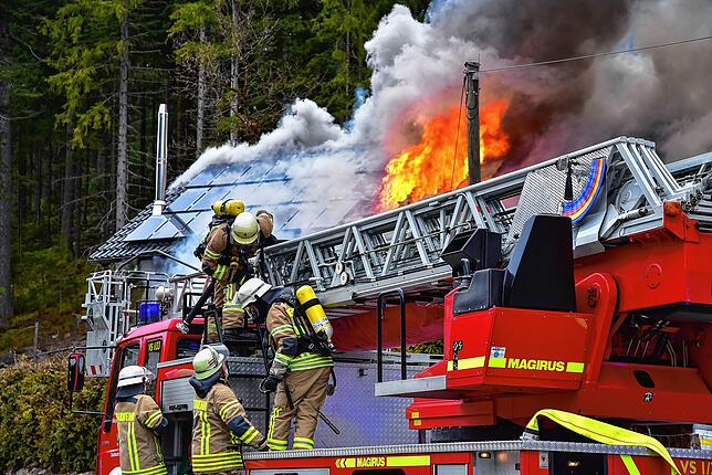 Die Feuerwehr bringt im Groppertal eine Drehleiter in Stellung, um die Flammen von oben zu bekämpfen.