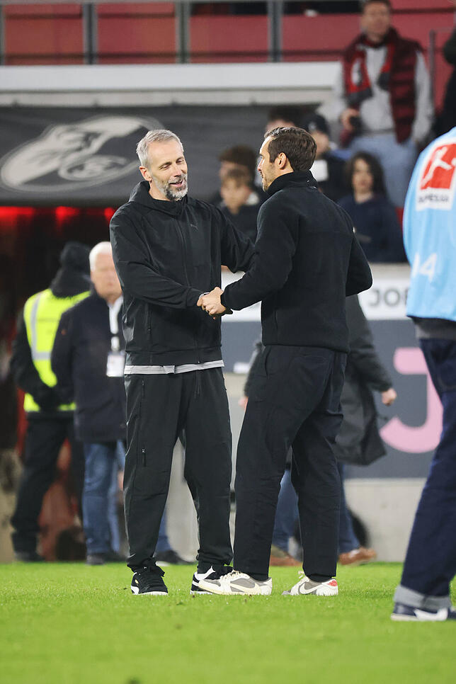Leipzigs Cheftrainer Marco Rose (l) und Freiburgs Cheftrainer Julian Schuster (r) unterhalten sich nach Spielende.