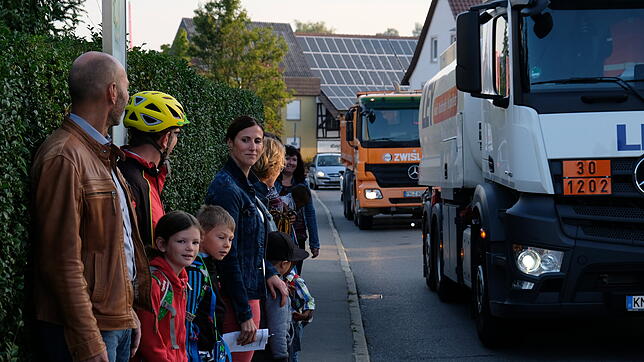 Während die Grundschulkinder in Unterraderach auf dem schmalen Gehweg auf ihren Schulbus warten, fahren dicht vor ihnen die Lastwagen ...