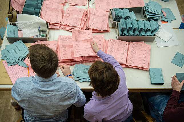 Ehrenamtliche Wahlhelfer beteiligen sich an der Stimmauszählung der Briefwahl. Im Veranstaltungszentrum werden die Stimmen der Briefwahl ...