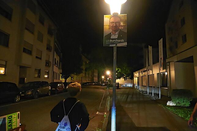 Analyse der Konkurrenz: Hannah Gerster vor einem Plakat des Amtsinhabers.