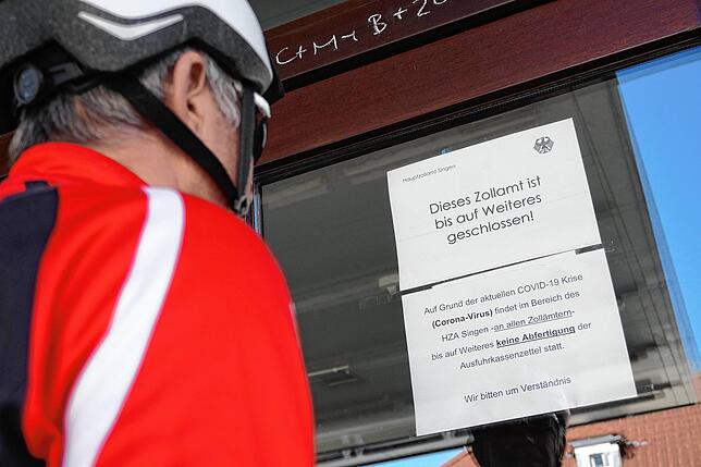 Ein Schweizer Radfahrer betrachtet am Zoll in Waldshut den Aushang, der über die vorläufige Einstellung der Mehrwertsteuerrückerstattung ...