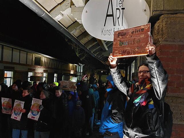 Ulrike Neumann-Weber hält in der Demo ihr Plakat hoch.