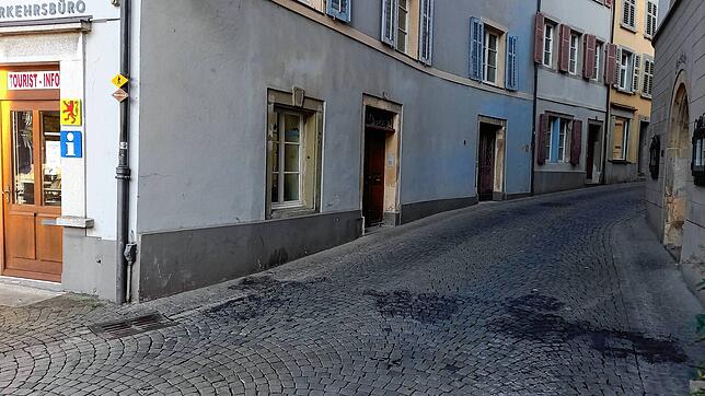 Die verkohlten Flecken auf dem Pflaster zeigen die Stelle an, wo die Möbel am frühen Morgen des 16. August angezündet wurden. Rechts ist ...
