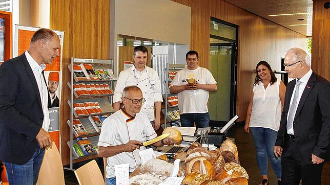 Brotprüfer Karl-Ernst Schmalz (sitzend) mit (von links) OB Bernd Häusler, den Bäckermeistern Eric Stadelhofer und Andreas Auer, Nadine ...