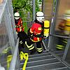 Zwei Einsatzkräfte der Feuerwehr tragen bei der Probe eine bewusstlose Person aus dem Gebäude der Zeppelin-Realschule. Für den ...