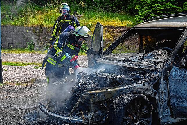 Sorgsam löscht ein Feuerwehrmann den Brand des Autos.