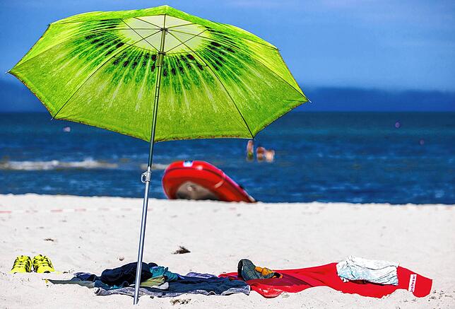 Ein großer Sonnenschirm steht am Strand an der Ostseeküste.Besonders bei Auslandsreisen kann einiges schief gehen, auch bei Pauschalreisen.