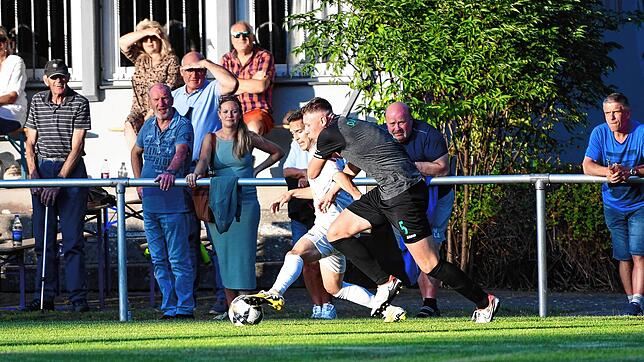 Direkt vor den Zuschauern kämpfen der Tannheimer Marvin Karisan (weißes Trikot) und Nino Schwirz von der DJK Villingen um den Ball. ...