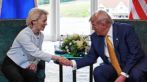US-Präsident Donald Trump schüttelt der Präsidentin der Europäischen Kommission Ursula von der Leyen die Hand, während sie sich auf dem ...