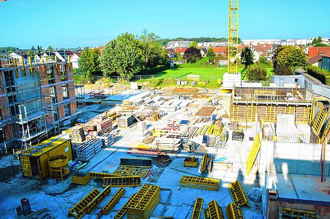Hier sollen später die Häuser Nummer fünf und sechs stehen. Arbeiter sind derzeit mit dem Rohbau der Gebäude beschäftigt.