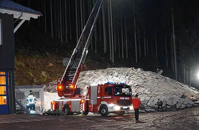 Die Feuerwehr ist aktiv im Einsatz, um den Schnee-Berg abzudecken. Auch die Drehleiter wird für die Beleuchtung genutzt.