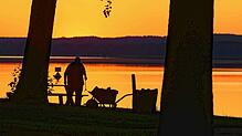 Ein Mann reinigt am frühen Morgen des 2.7.2025 eine Liegewiese am Scharmützelsee. Der Deutsche Wetterdienst rechnet mit ...