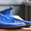 Gegen stechende Steine helfen Badeschuhe. Doch die unterschiedlichen Modelle haben verschiedene Vor- und Nachteile.