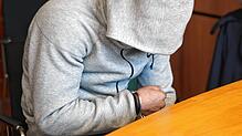 (Archivbild) Der Angeklagte sitzt in Handschellen am ersten Prozesstag, 10. Januar, im Gerichtssaal und zieht seine Kapuze vor Beginn ...